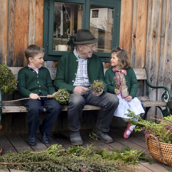Großvater und Enkelkinder beim Palmbuschenbinden  | © c Steiermark Tourismus / bigshot.at | Erich Hagspiel