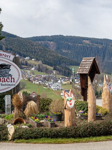 Ortstafel Fischbach umrundet von hölzernen Osterhasen | ©  Oststeiermark Tourismus | Rene Strasser