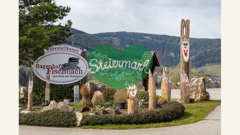 Ortstafel Fischbach umrundet von hölzernen Osterhasen | ©  Oststeiermark Tourismus | Rene Strasser