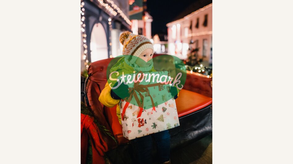 Kind mit Geschenk beim Weihnachtszauber in Hartberg | © Oststeiermark Tourismus | studio draussen