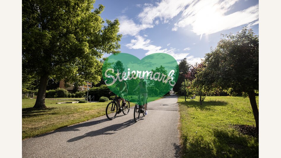 Pärchen fährt mit dem Fahrrad durch die Parkanlage vom Hotel Steirerrast in Kaindorf | © Oststeiermark Tourismus | Velontour