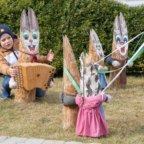 Kind hinter Osterhasen mit Holzharmonika in Fischbach | © TV Oststeiermark | Rene Strasser