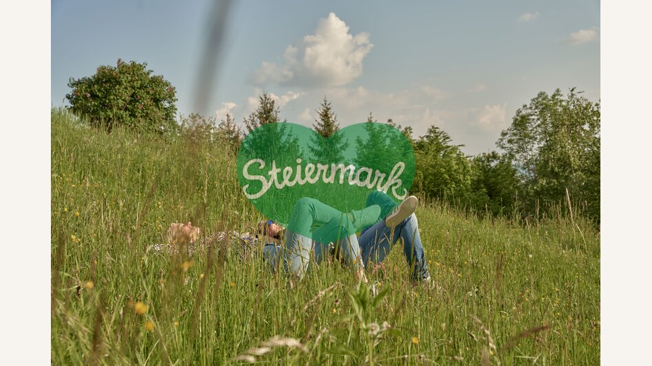 Paar liegt auf der Wiese in der Sonne am Pöllauberg in der Oststeiermark | ©  Oststeiermark Tourismus | Markus Lang-Bichl
