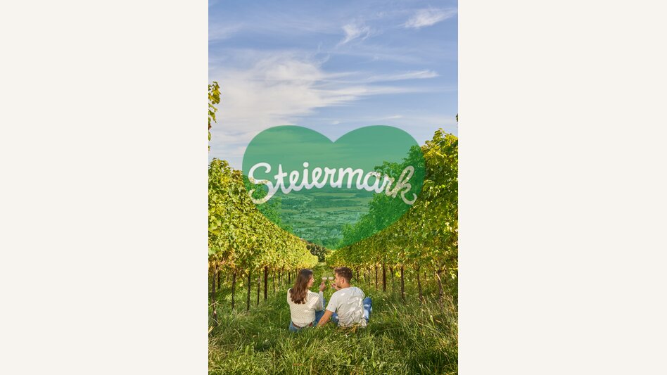 Paar sitzt in der Wiese in einem Weingarten und trinkt Wein in Hartberg in der Oststeiermark | ©  Oststeiermark Tourismus | Markus Lang-Bichl