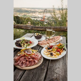 Buschenschank Jause beim Weinhof Postl am Ringkogel mit Aussicht auf Hartberg in der Oststeiermark | Discover Austria | © Oststeiermark Tourismus, Discover Austria