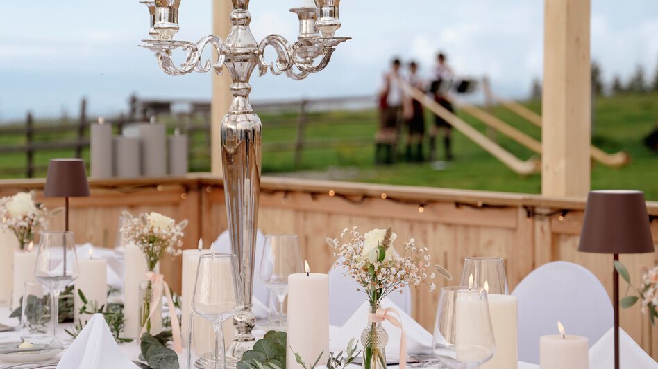 Candle chandelier on the table with alphorn players in the background | © Graz Region | www.wolfganghummer.com
