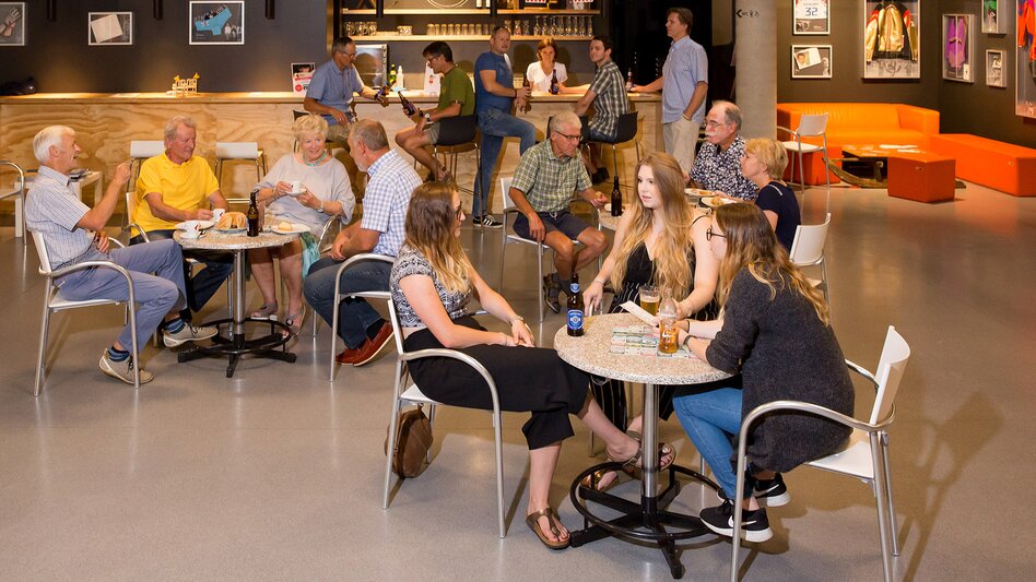 Menschen beim gemütlichen Beisammensein | © WinterSportMuseum