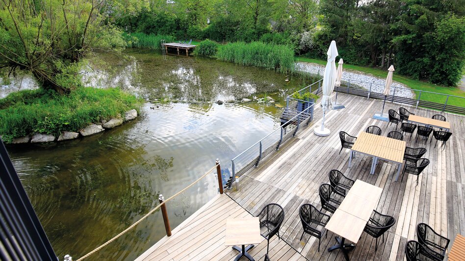 Blick auf die großzügige Terrasse und den hauseigenen Natursee | © DORMERO SeHo Graz