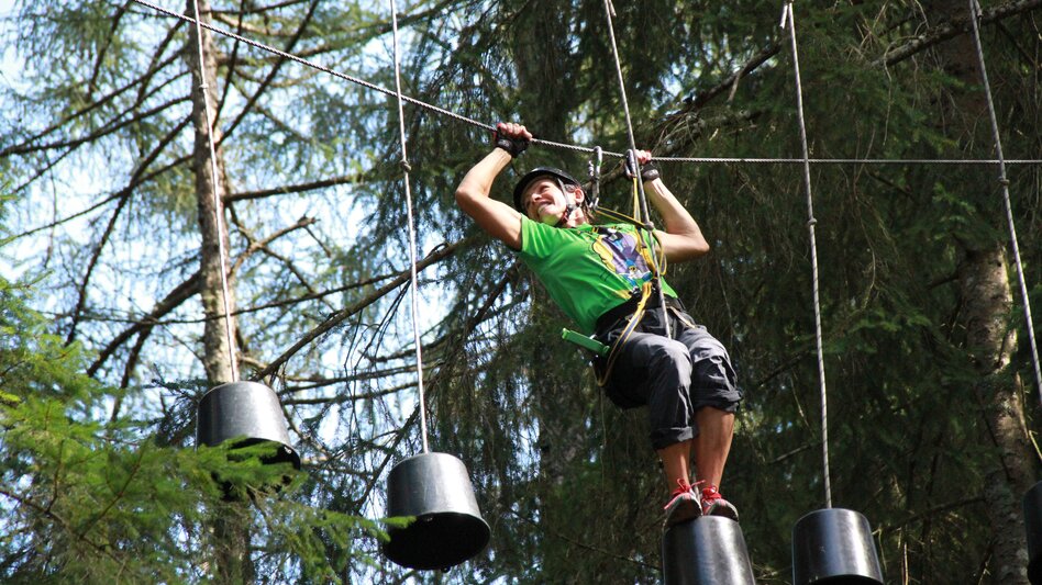 Junge beim Überwinden von hängenden Eimern