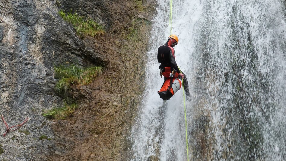 Person beim Abseilen im Wasserfall | © BAC