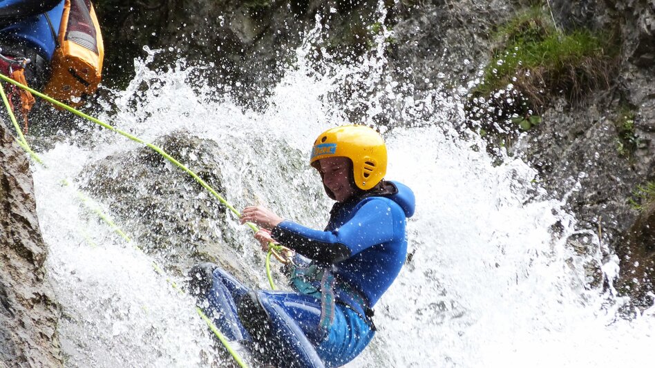 Junge Dame beim Abseilen im Wasserfall | © BAC