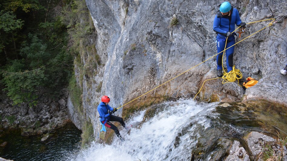Zwei Personen beim Abseilen am Wasserfall | © BAC