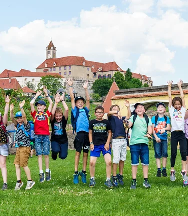 Eine Schulklasse freut sich! Im Hintergrund die Riegersburg. | © Burg Riegersburg | Ferder