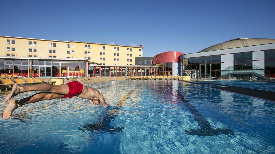 Mann springt kopfüber ins Becken