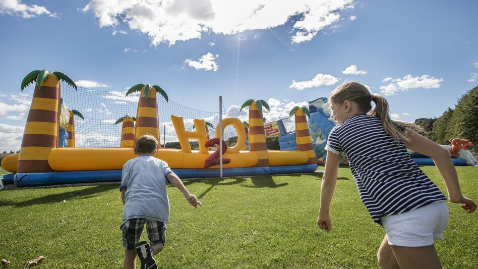 Zwei Kinder vor einer riesigen Hüpfburg