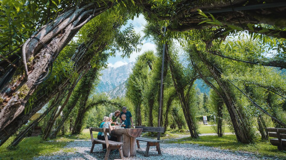 Familie unter dem begrünten Weidendom