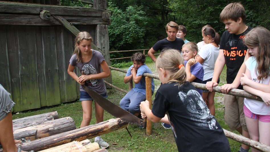 Museumsrallye - Kinder beim Durchsägen eines Stammes
