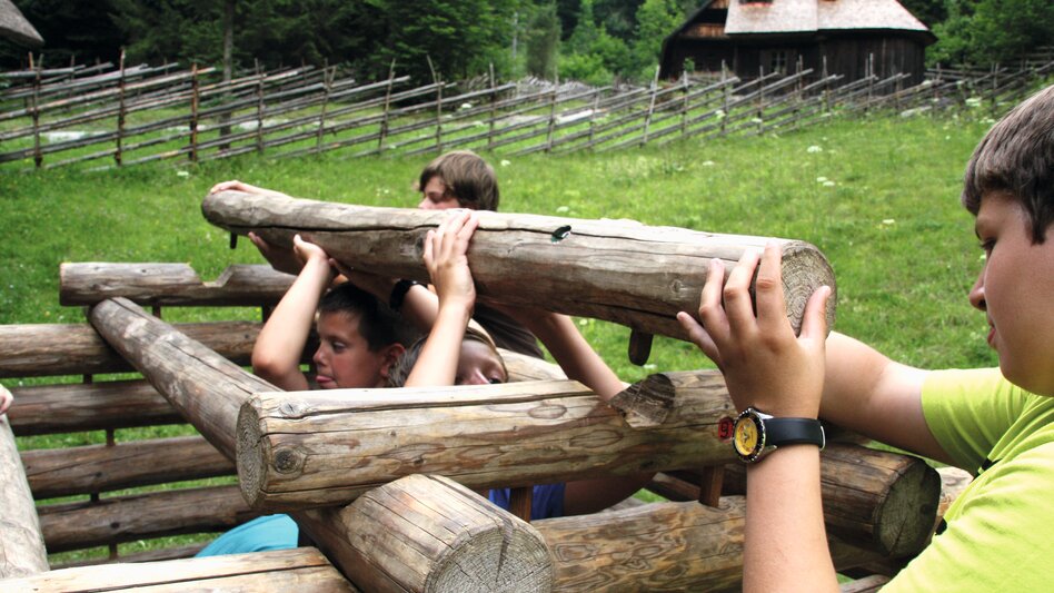 Kinder beim Miniatur Blockhaus bauen