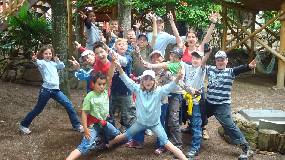 Kindergruppe vor Baumhäusern