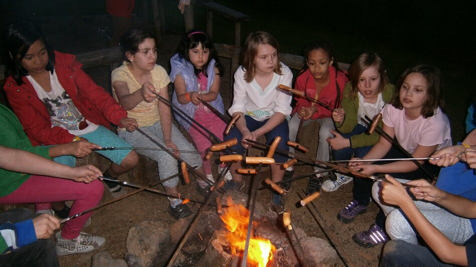 Kinder beim Grillen am Lagerfeuer