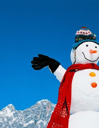 Schneemann vor der Kulisse des Dachstein-Massiv | Ikarus.cc | © Ikarus.cc