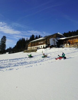 Kids snowtubing at Rösteralm in Vorberg | Stoanerhof | © Stoanerhof