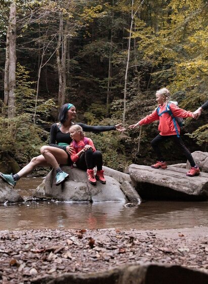 Familie auf Steinen im Bach bei einer Wanderung im Wald | © TVB Südsteiermark/Nadine Geuter | Nadine Geuter | © TVB Südsteiermark/Nadine Geuter
