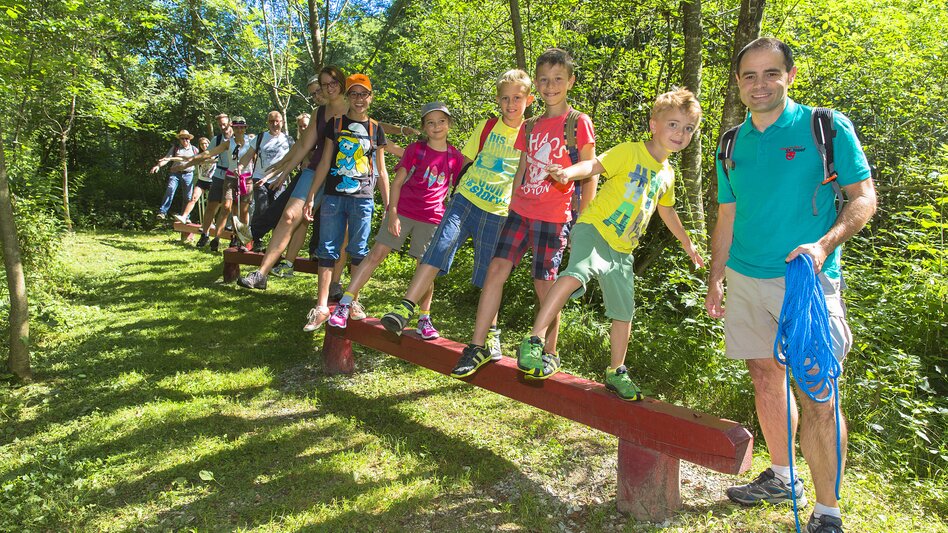 Kinder balancieren auf einem Holzbalken