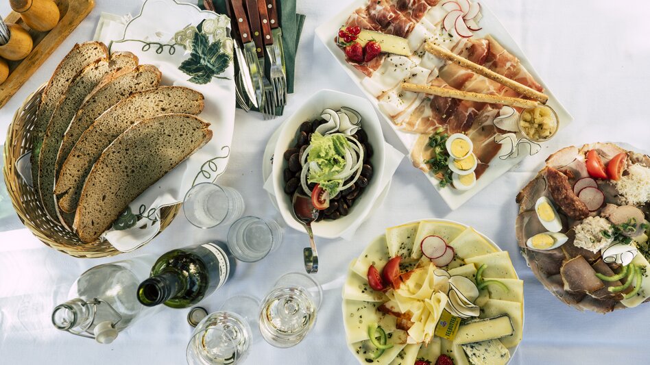 Buschenschank Bockmoar in Wildon: man kann direkt zwischen den Weinreben sitzen, jausnen & ein gutes Glaserl Wein trinken, außerdem gibt’s dort das allerbeste Buschenschankbrot (meistens noch lauwarm & so richtig schön knusprig) - Lisa Anderle  | © STG | Bernhard Bergmann