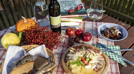 Snack in a typical wine tavern (Buschenschank) in Southern Styria with reading material | © Steiermark Tourismus | Harry Schiffer