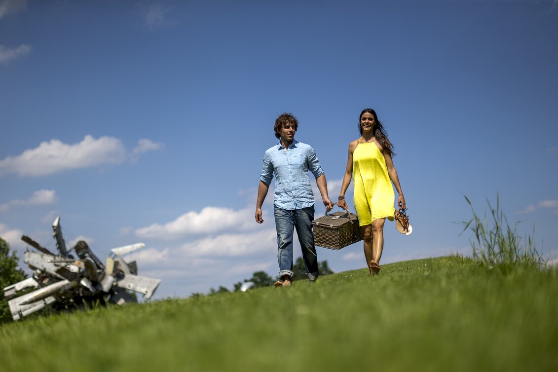 Picknick im Skulpturenpark, im Hintergrund Nancy Rubins, Airplane Parts and Hills, 2003 | © Region Graz - Skulpturenpark, im Hintergrund Nancy Rubins, Airplane Parts and Hills | Tom Lamm