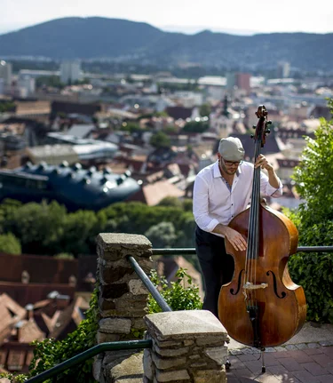 Musician above the roofs of Graz | © Steiermark Tourismus | Tom Lamm