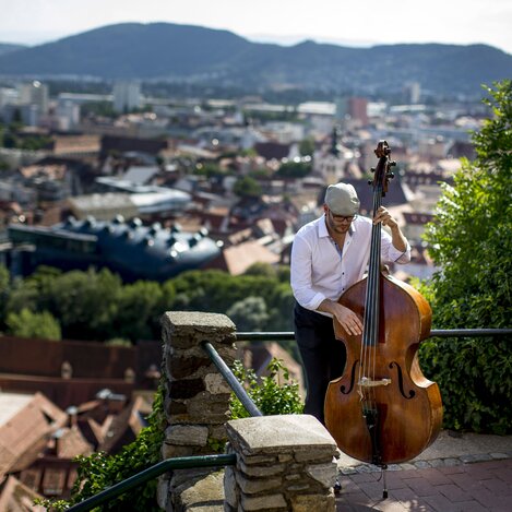 Musician above the roofs of Graz | © Steiermark Tourismus | Tom Lamm