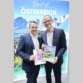 Michael Feiertag (GF Steirische Tourismus und Standortmarketing Gmbh) und Klaus Ehrenbrandtner (GF Kärnten Werbung) mit dem neuen 2-Länder-ADAC Magazin auf der ITB 2025 in Berlin.  | Sascha Radke