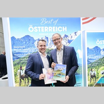 Michael Feiertag (GF Steirische Tourismus und Standortmarketing Gmbh) und Klaus Ehrenbrandtner (GF Kärnten Werbung) mit dem neuen 2-Länder-ADAC Magazin auf der ITB 2025 in Berlin.  | © Österreich Werbung | Sascha Radke
