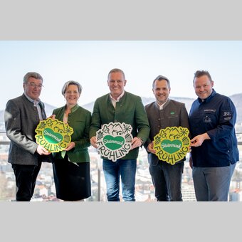 Gruppe von links: Josef Rieberer (GF Brauerei Murau), Evelyn Schweinzger (GF Erlebnisregion Südsteiermark), Landeshauptmann Mario Kunasek, Michael Feiertag (GF STG/Sterische Tourismus und Standortmarketing GmbH) und Sterne- und Haubenkoch Richard Rauch mit neuem Steiermark-Frühling-Logo für den großen Steiermark-Auftritt in Wien bei strahlendem Sonnenschein mit Ausblick über Graz. | © STG | Jaden Gynes