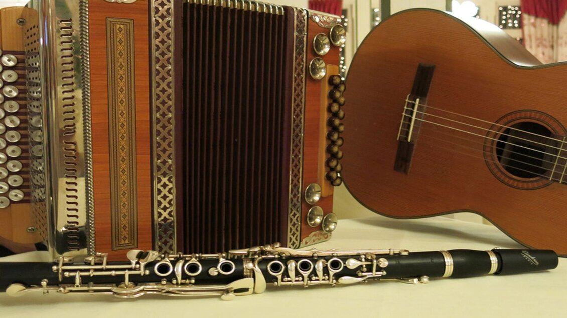 Eine Auswahl von Musikinstrumenten liegt auf einem Tisch. Darunter befinden sich ein Akkordeon, eine Gitarre und eine Querflöte. | © Hotel Seevilla