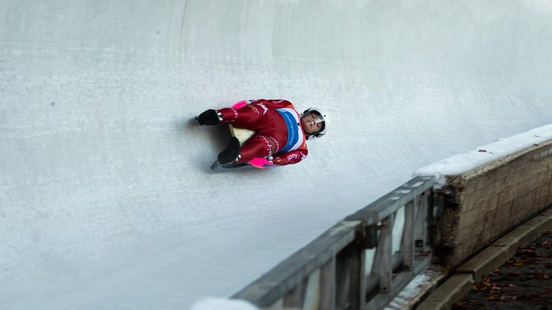 Ein Rodler fährt die Rennstrecke in voller Geschwindigkeit. Er trägt einen roten Anzug und einen Schutzhelm. | © Pixabay