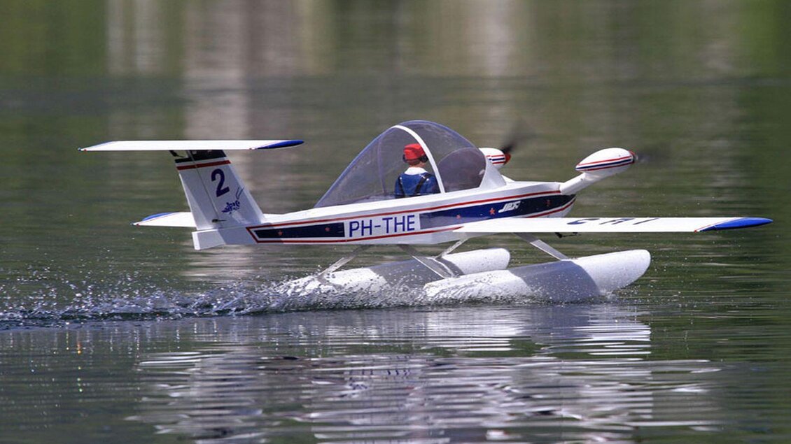 Ein Wasserflugzeug fliegt über einen ruhigen See. Es spritzt Wasser auf, während es sich in der Luft bewegt. | © Ian Walter