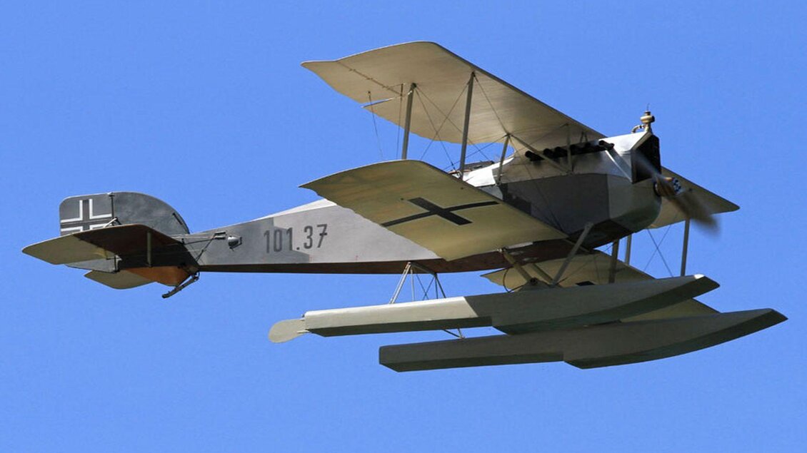Ein historisches Wasserflugzeug fliegt durch den blauen Himmel. Die Flugzeugoberfläche ist grau mit einem schwarzen Kreuz. | © Ian Walter