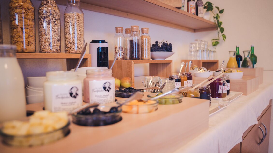 Ein hübsches Buffet mit verschiedenen Lebensmitteln und Getränken. Es gibt Gläser mit Müsli, Joghurt, Obst und Säfte. | © Martinhof