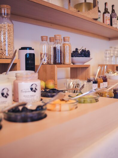 A lovely buffet with various foods and drinks. There are glasses with muesli, yogurt, fruit, and juices. | © Martinhof