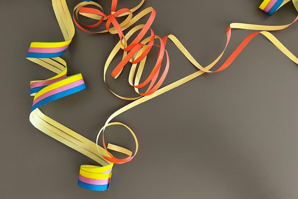 Bunte Geschenkband-Reste liegen chaotisch auf einem dunklen Untergrund. Die Farben umfassen Rot, Gelb, Blau und Grün. | © TV Thermen- & Vulkanland