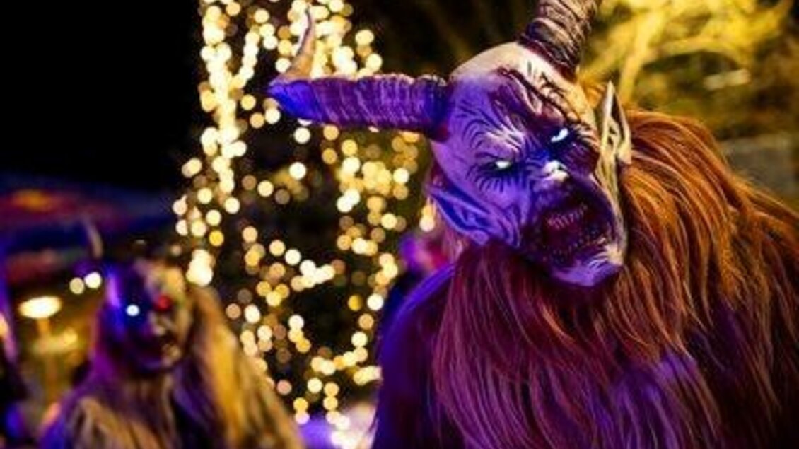 Eine gruselige Halloween-Szene mit maskierten Figuren, die dämonisch aussehen. Im Hintergrund leuchten Lichter und es gibt festliche Elemente. | © Red Bull Ring