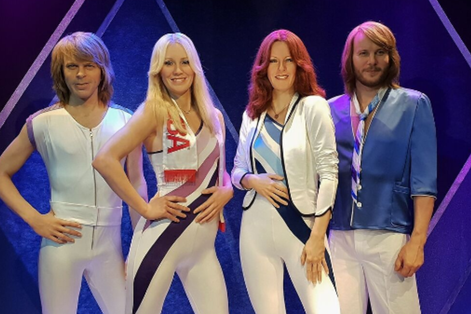 Bunte Silhouetten von vier Personen auf einer Bühne unter bunten Lichtern. Der Hintergrund ist schwarz mit funkelnden Effekten. | © Pixabay