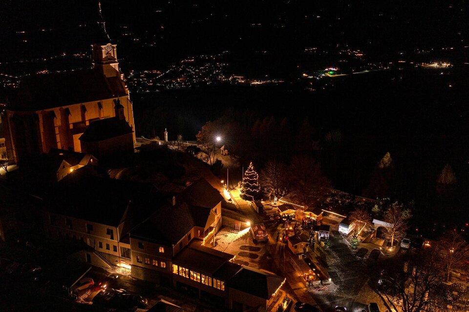 Eine malerische Stadtansicht bei Nacht mit beleuchteten Gebäuden und einer Kirche. Der Himmel ist dunkel, und die Lichter der Umgebung schaffen eine gemütliche Atmosphäre. | © ©Rene Strasser