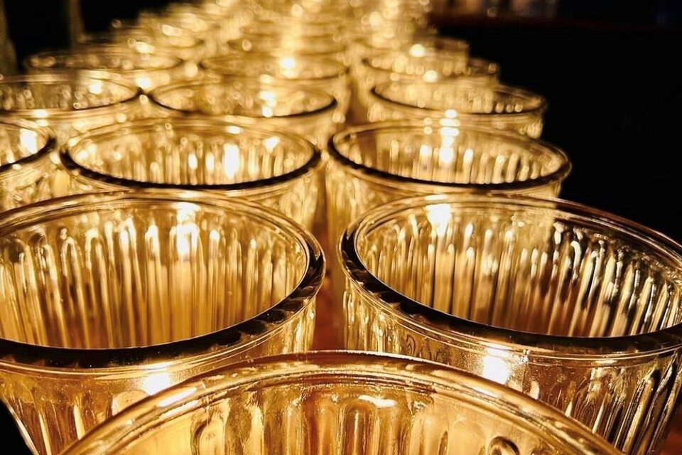 Eine Reihe von transparenten Gläsern, die sanft leuchten. Die Gläser sind in einem dunklen Raum angeordnet und schaffen eine warme Atmosphäre. | © Rainer Böhm