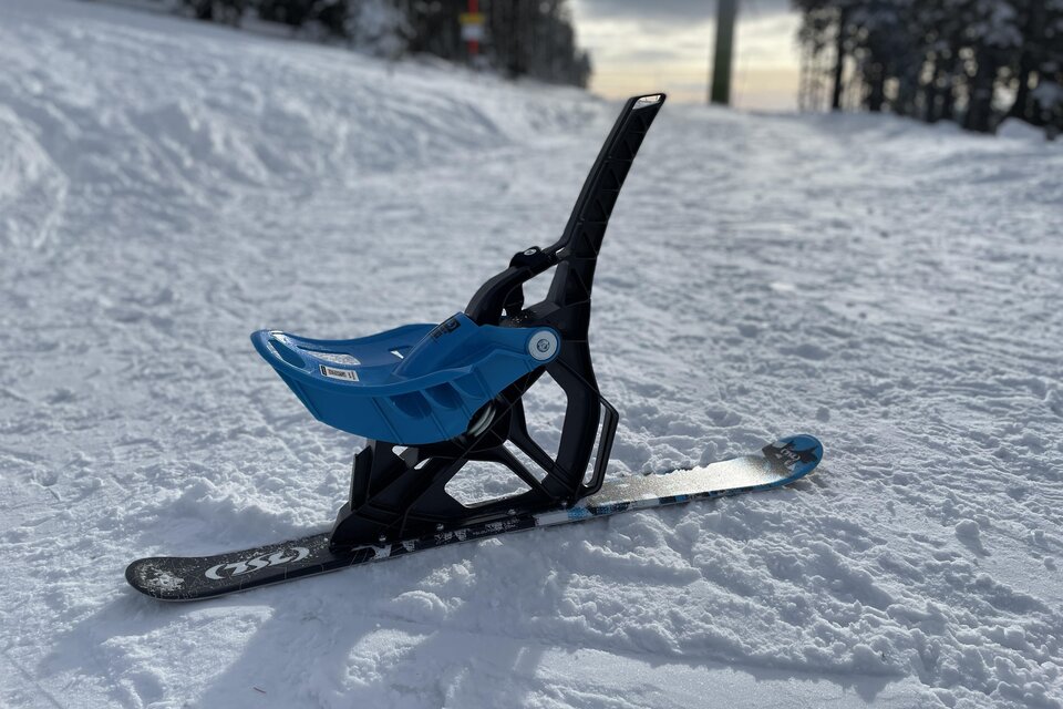 Ein blauer Schlitten steht auf der verschneiten Piste. Im Hintergrund sind schneebedeckte Bäume sichtbar. | © Steirisch Wandern