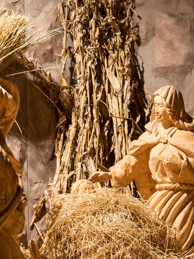 An artistic Christmas motif featuring figures that depict Mary and Joseph. The scene is designed with hay and natural materials. | © Ulricht Thausing