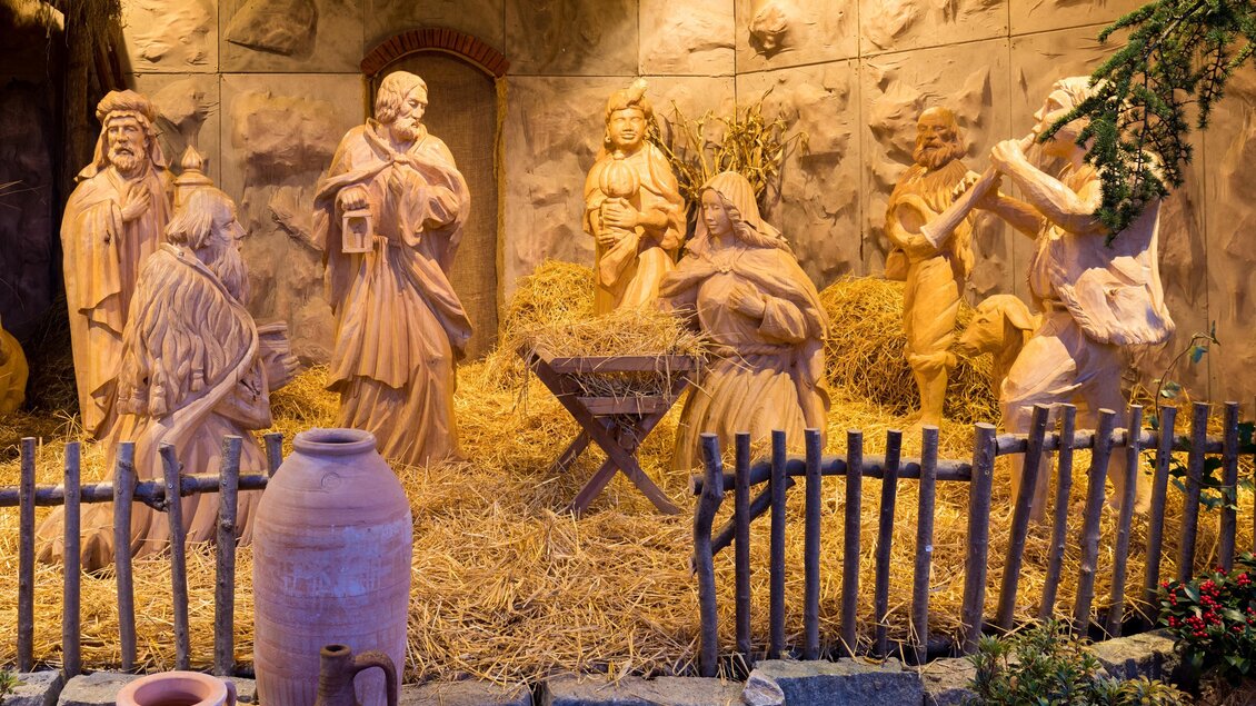 Eine Krippe mit Holzfiguren, die die Geburt Jesu darstellen. Umgeben von Heu und einer rustikalen Umgebung. | © TV Region Graz-Harry Schiffer
